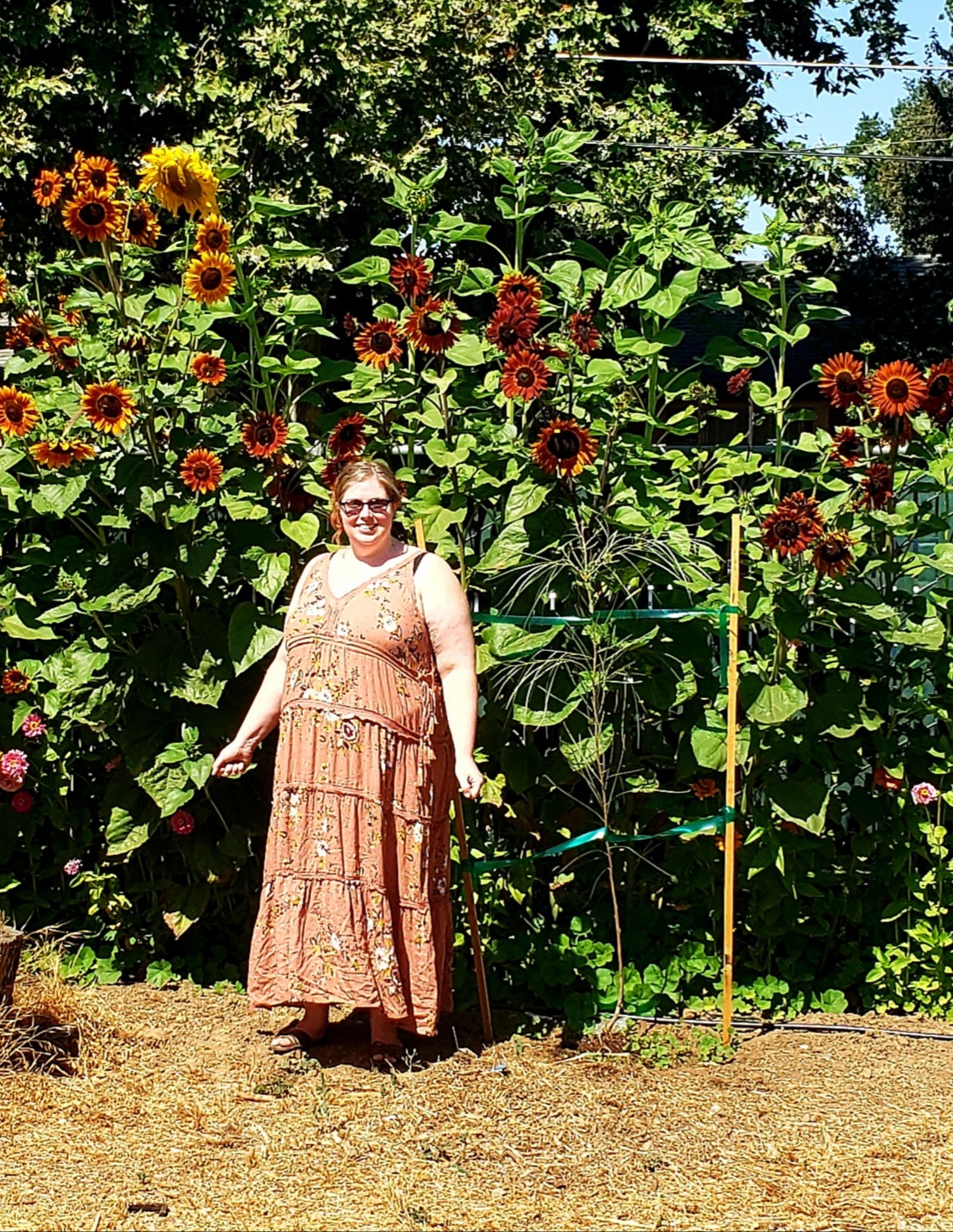 Christine standing in front of a group of sunflowers