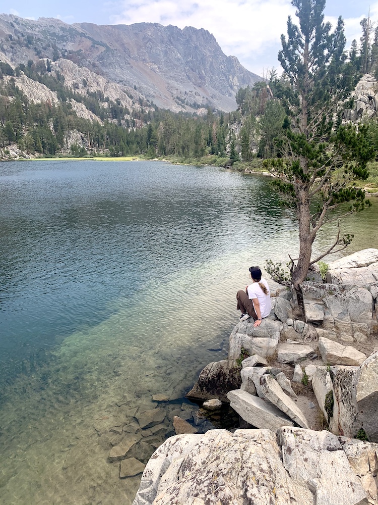 Person sitting by a lake