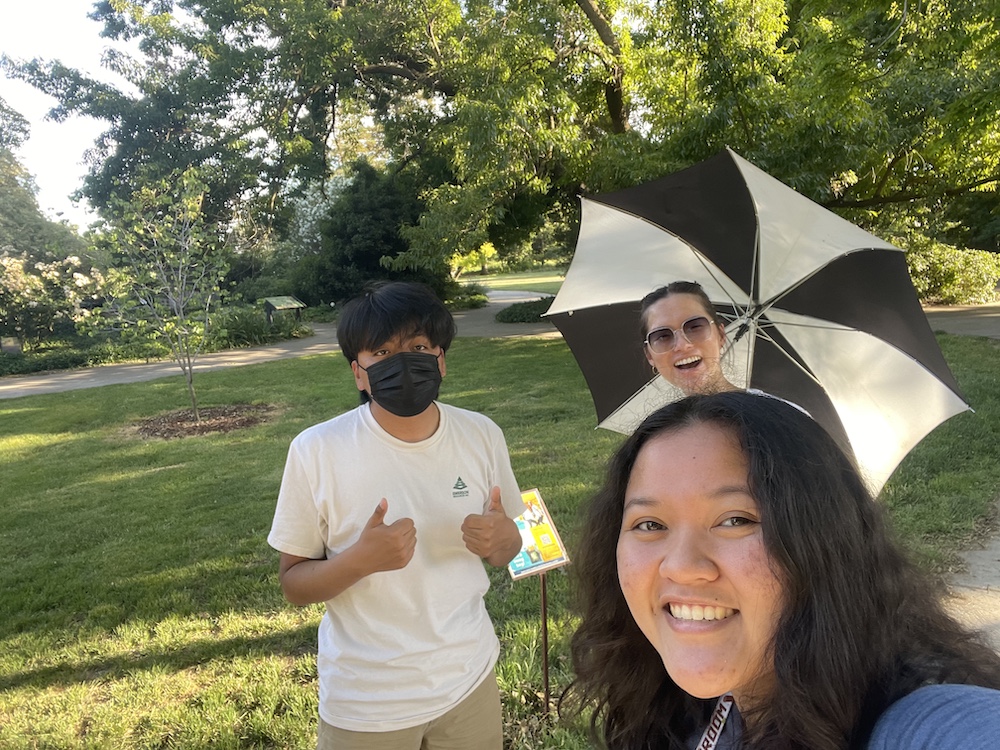 Three people pose for a photo in the Arboretum
