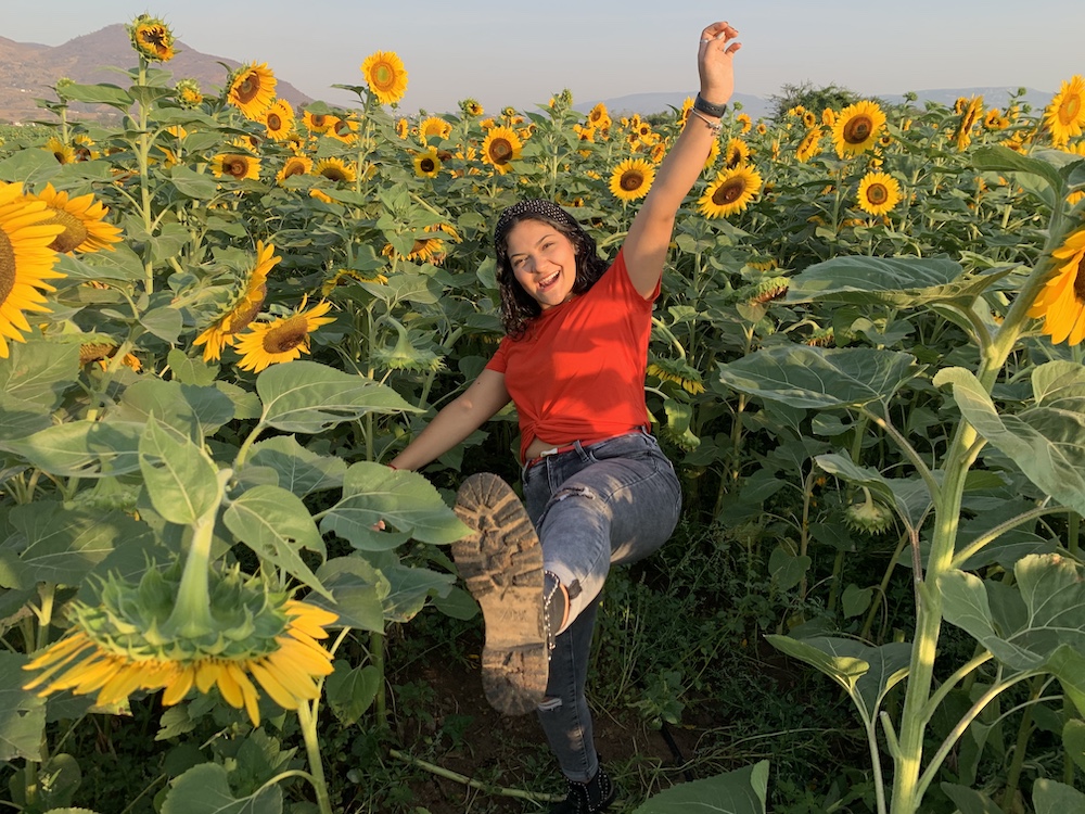 Hannia posing in a field of sunflowers