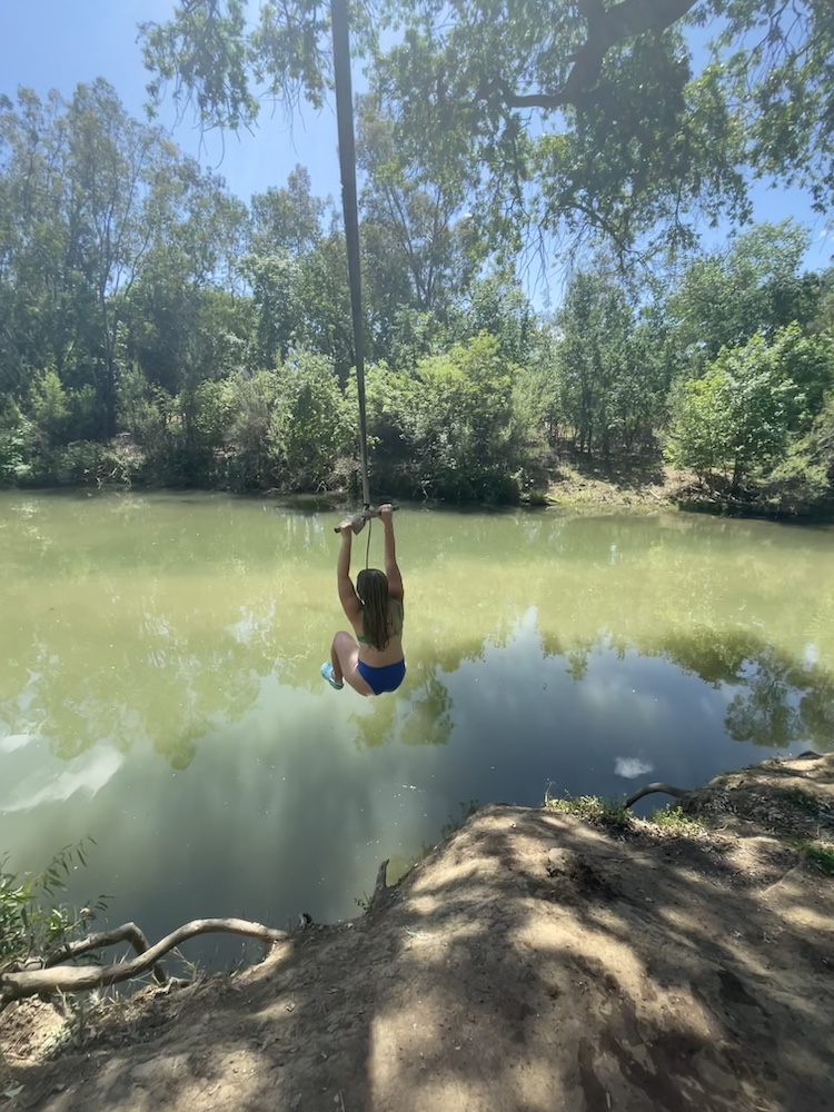 Person swinging into a creek