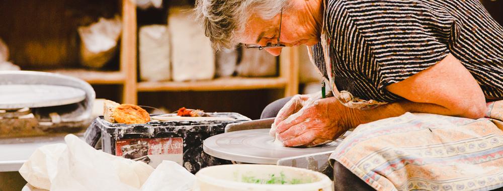 older woman using a potters wheel uc davis craft center