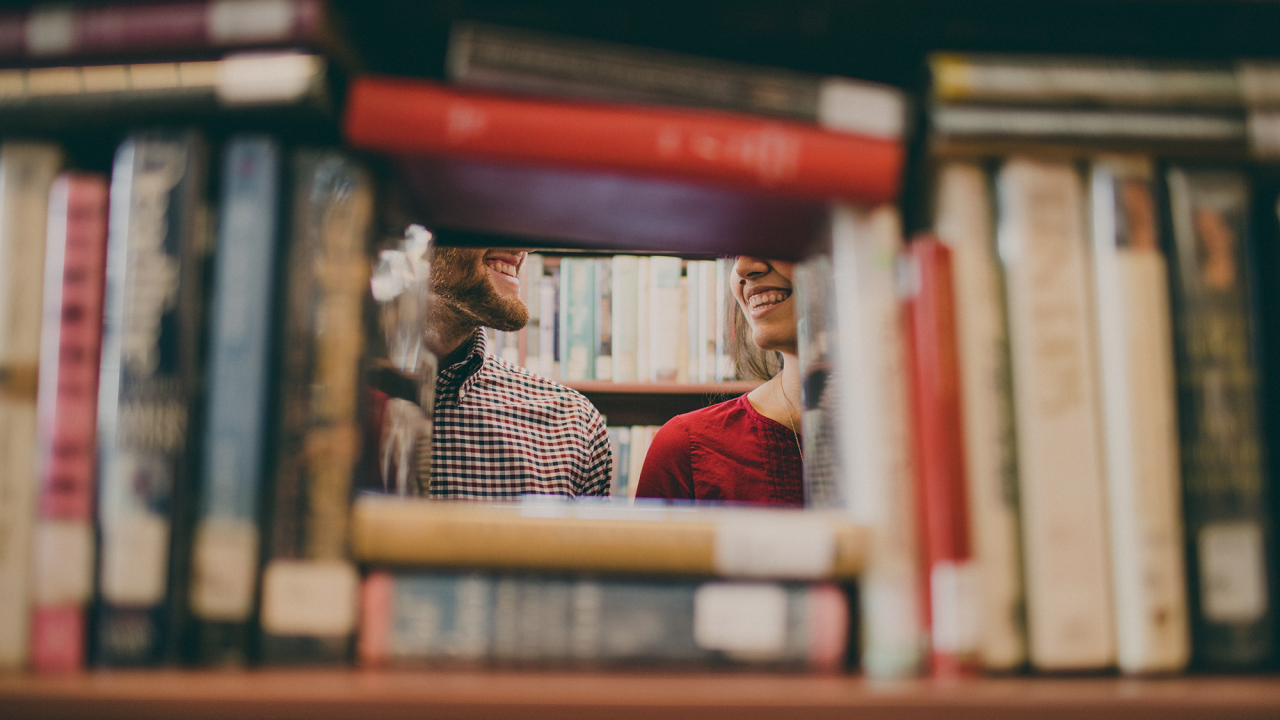 two people viewed with a stack of books