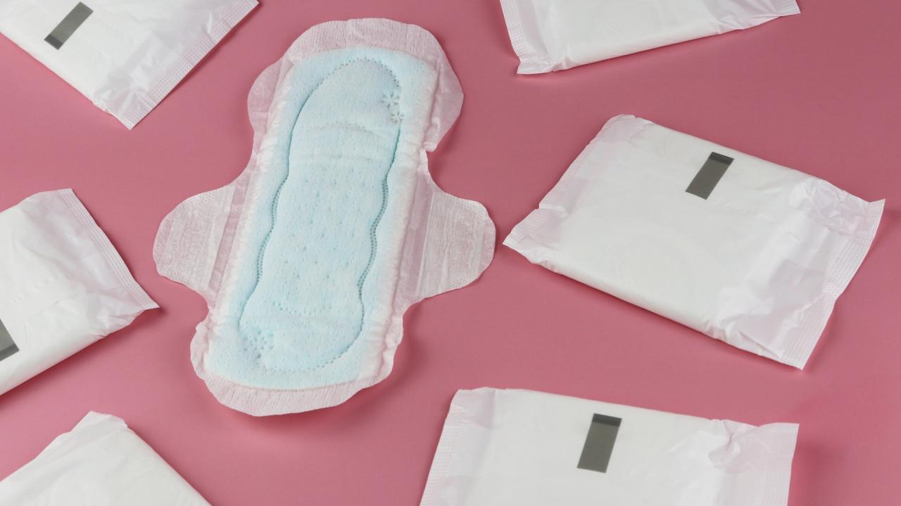 white period pads scattered across a pink surface