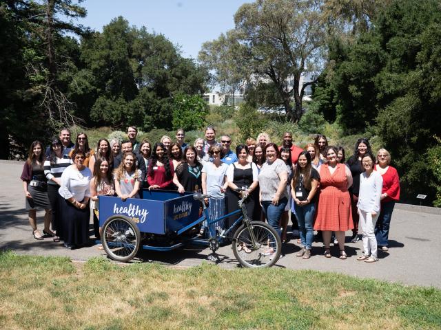 Healthy UC Davis gathered in arboretum with bike