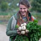 uc davis student farm worker with an armful of vegetables
