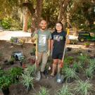two volunteers posing for a photo during a memorial garden planting event