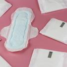 white period pads scattered across a pink surface